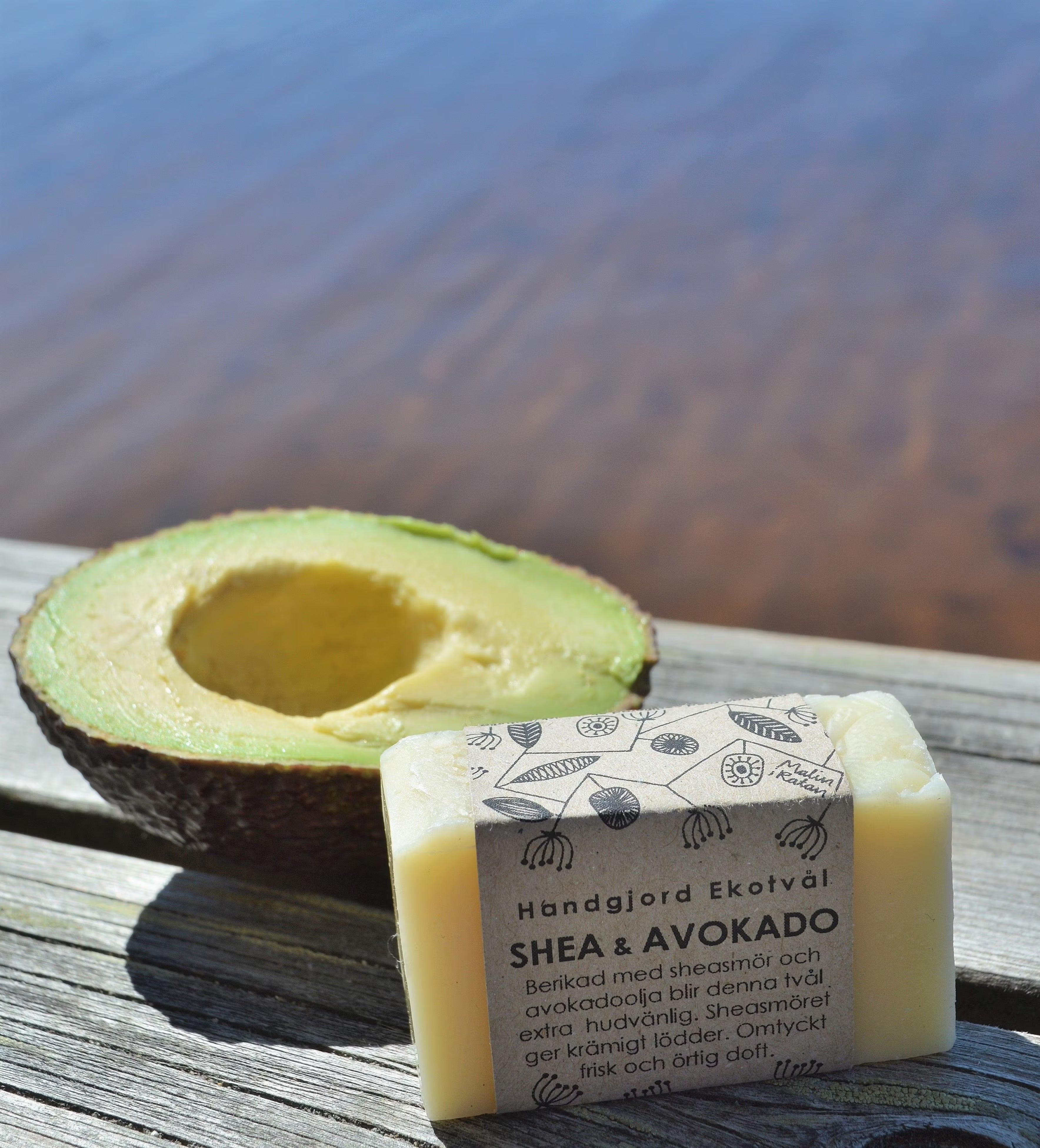 Naturlig tvål som är gjord för hand med naturligt innehåll. Stor del Sheasmör och avokadoolja. Tvålen ligger på en brygga precis bredvid vattnet. Passar perfekt för en naturlig och hållbar livsstil